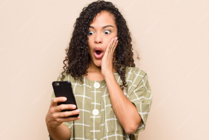 imagem de mulher surpresa com celular Entre no grupo de promoções do PPV e não perca dicas de milhas, cashback e ofertas