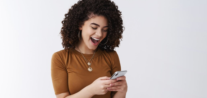 mulher feliz com celular Descubra como receber +400 alertas de emissões direto no seu celular